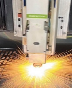 A laser cutting machine with sparks
Description automatically generated