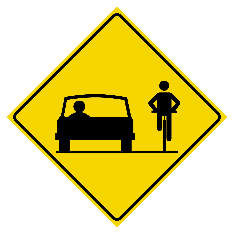 A yellow road sign with a person on a bicycle and a car
Description automatically generated