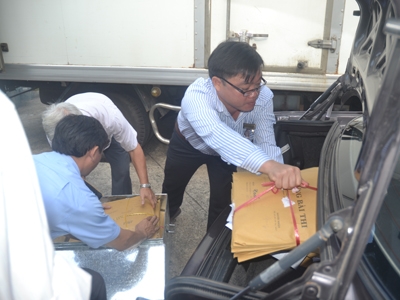 Đại diện các trường ĐH tại TPHCM nhận bài thi và chuyển các túi bài thi lên xe để đưa về trường
            chấm thi. Ảnh: Quang Phương