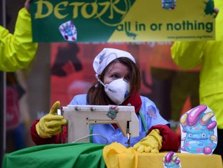 Nhà hoạt động Greenpeace đóng làm công nhân may quần áo chứa hóa chất độc như những con quỷ nhỏ.